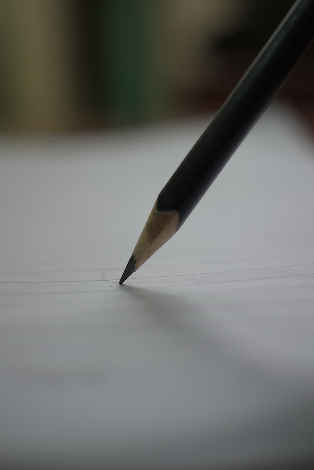رأس قلم رصاص يكتب على ورقة مسطرة